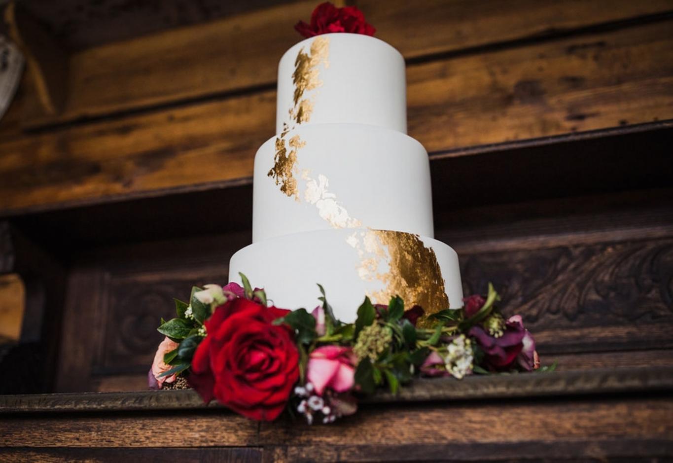 gold leaf design and floral decorations wedding cake