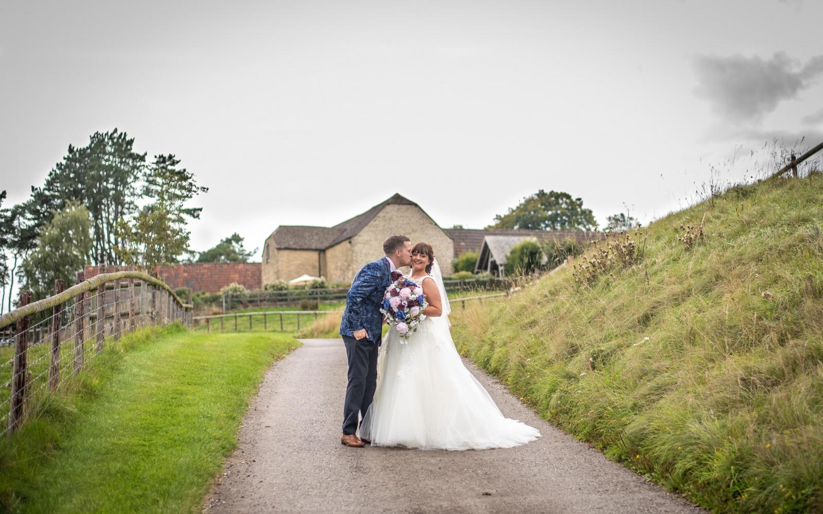 Real Wedding Strike A Pose Photography Wiltshire wedding photographer Kingscote Barn Tetbury Gloucestershire groom kisses his bride