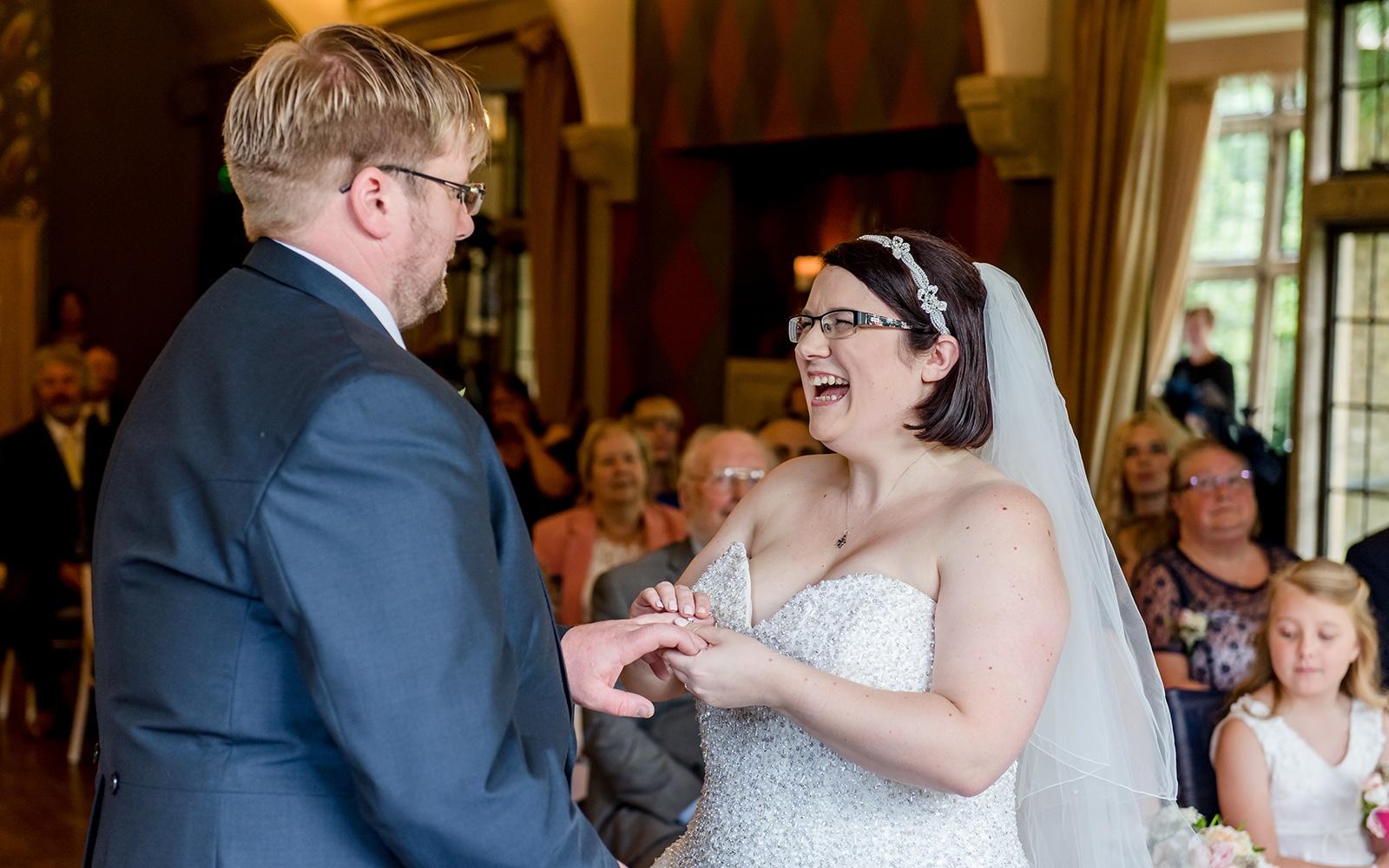 Capture Every Moment Real Wedding Photography Photographer duo Cirencester Hare and Hound Tetbury giggles during ceremony navy grooms suit