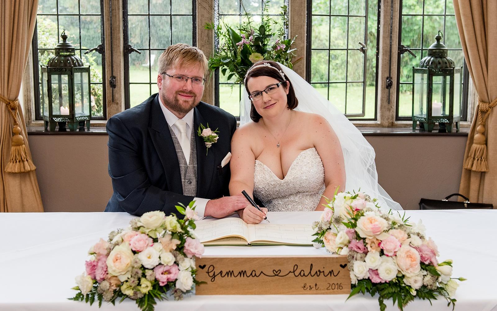 Capture Every Moment Real Wedding Photography Photographer duo Cirencester Hare and Hound Tetbury signing the register personalised wooden sign