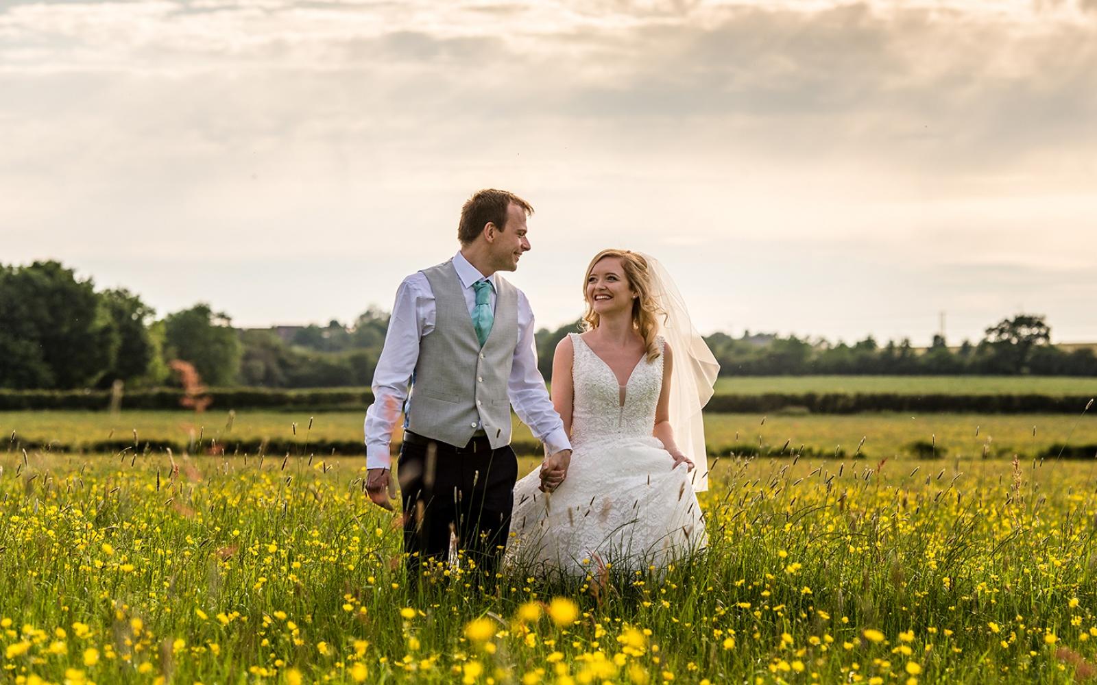 Capture Every Moment real wedding photography duo photographer Cirencester  Church of St Mary The Virgin Bampton Spittleborough Farm Wiltshire walking in the fields short veil 