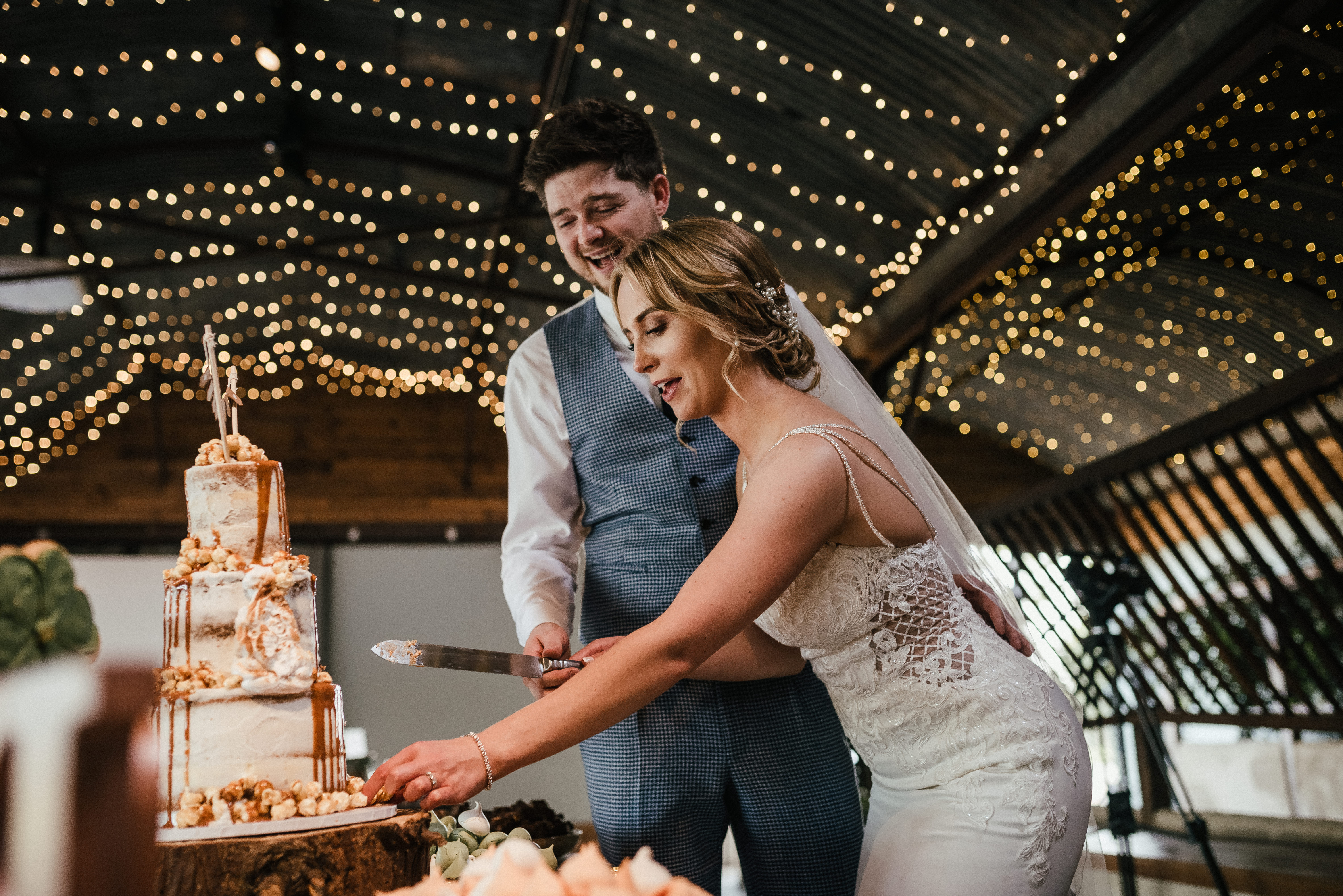 The Whitewed Directory from the professionals blog lets talk cake wedding suppliers cakemakers Cakes by Mrs F Hannah Culley's Cakes Kimmi's Cakes cutting the cake twinkling lights ceiling drapes
